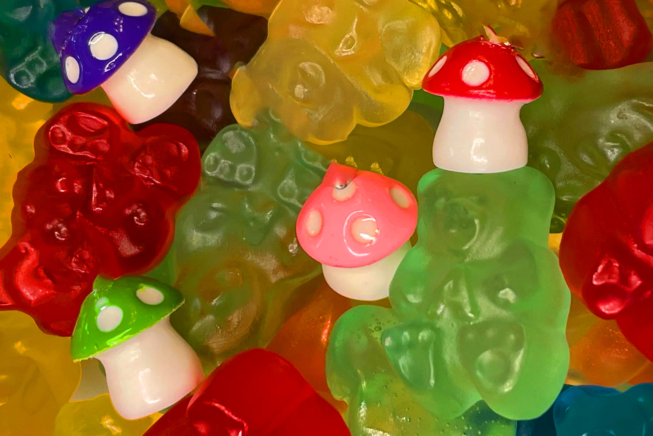 Colorful gummy bears and mushroom-shaped gummy candies in red, green, purple, and pink